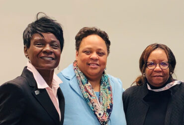 Three smiling businesswomen together at a procurement industry event